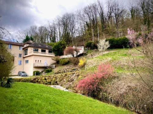 a large house on top of a grassy hill at Domaine Du Moulin Vallée Heureuse in Poligny