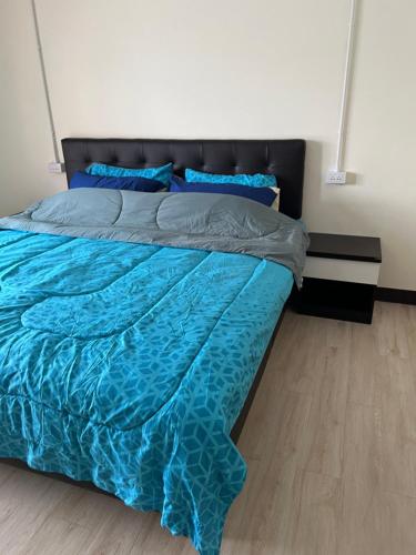 1 dormitorio con 1 cama con sábanas azules y almohadas azules en Sea skyline home en Sattahip