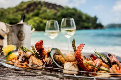 - une assiette de fruits de mer et de verres à vin sur une table à la plage dans l'établissement Villa de famille 15 couchages, à Carnac