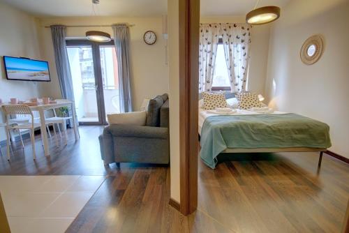 a bedroom with a bed and a couch and a table at HelApart - Foka in Hel