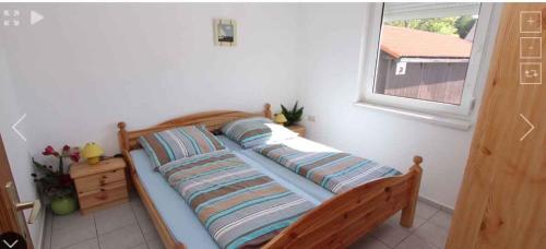 una cama en una habitación con ventana en Apartments in Gyenesdias - Balaton 36344, en Gyenesdiás