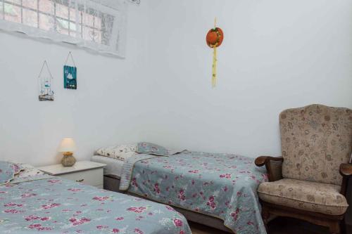 um quarto com 2 camas individuais e uma cadeira em Holiday Homes in Balatonboglar 40843 em Balatonboglár