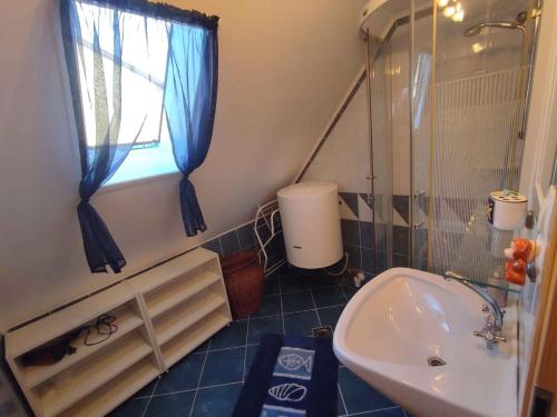 La salle de bains est pourvue d'un lavabo, d'une douche et d'une fenêtre. dans l'établissement Apartment in Fonyod - Balaton 43602, à Fonyód