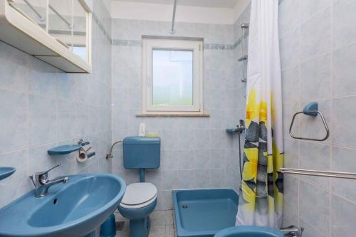 a bathroom with a blue sink and a toilet at Apartment in Skrpcici - Insel Krk 41816 in Skrbčići