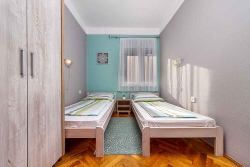 two beds in a small room with blue walls at Holiday home in Balatonmariafürdo 40848 in Balatonmáriafürdő