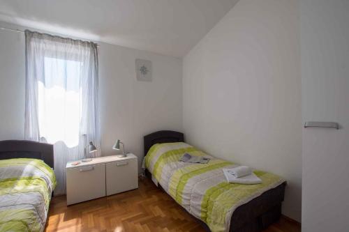 a bedroom with two beds and a window at Apartments in Umag - Istrien 26738 in Umag