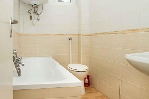 e bagno con vasca, servizi igienici e lavandino. di Holiday home in Balatonmariafürdo 36287 a Balatonmáriafürdő