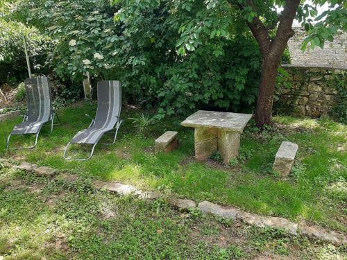 two chairs and a table and a bench and a tree at Holiday home in Krnica - Istrien 42505 in Krnica