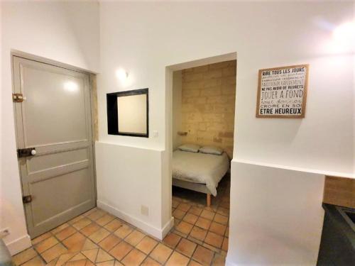 Cette petite chambre comprend un petit lit et une porte. dans l'établissement L'Appart de la rue Balze, à Arles