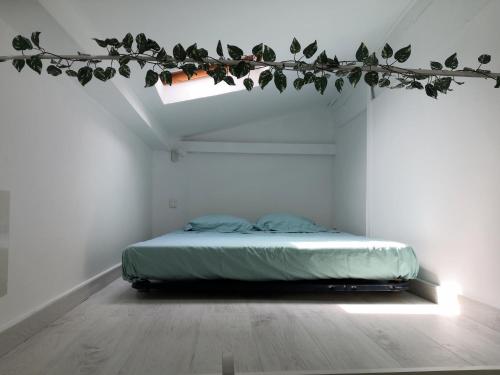 uma cama num quarto com um ramo com folhas em spacieux logement vieil antibes climatisé 5 minutes plages em Antibes