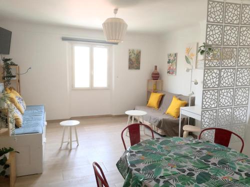 uma sala de estar com uma mesa e um sofá em spacieux logement vieil antibes climatisé 5 minutes plages em Antibes