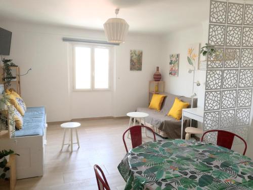 un salon avec une table et un canapé dans l'établissement spacieux logement vieil antibes climatisé 5 minutes plages, à Antibes
