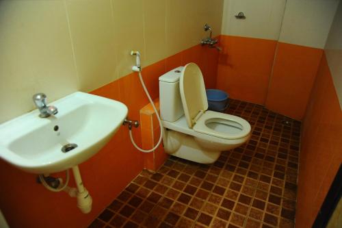 a bathroom with a toilet and a sink at Bhanu Residency in Tirupati