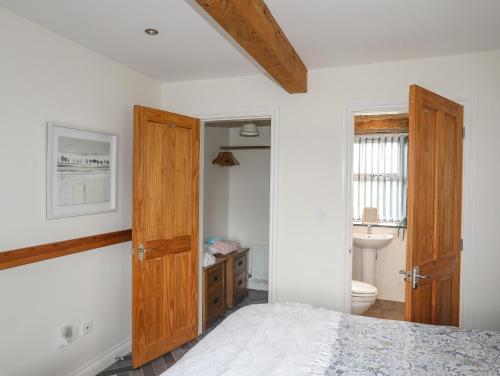 a bedroom with a bed and a bathroom with a toilet at Plas Cefn Mawr in Llanedwen