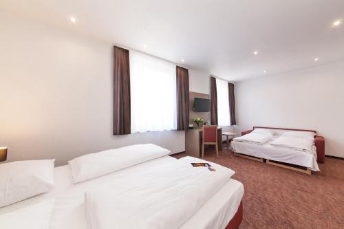 a hotel room with two beds and a window at Hotel Excelsior Dortmund Hauptbahnhof in Dortmund