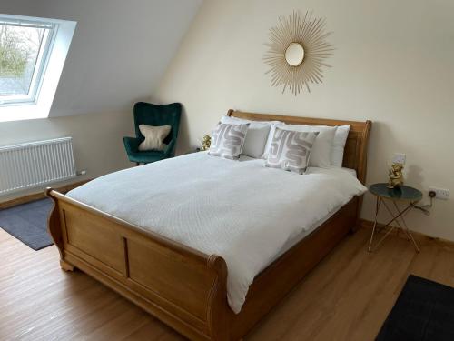 a bedroom with a large bed with a mirror on the wall at Buttercup Cottage at The Old Tractor Barn in Brackley