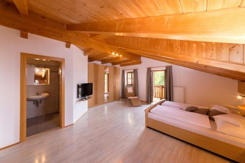 モンターニャにあるEngadiner Apartments & Winesの木製の天井の客室で、ベッドルーム1室(ベッド1台付)