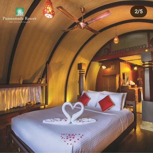 Un dormitorio con una cama con dos cisnes. en Punnamada Resort, en Alleppey