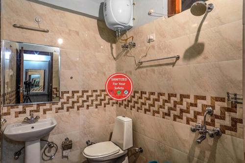 a bathroom with a toilet and a sink and a mirror at Hotel Sapphire Inn Bhimtal, Kaichi Dham - Parking Facilities - Best Luxury Hotel in Nainital in Nainital