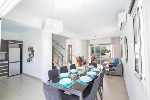 a dining room and living room with a table and chairs at Casa de Nicole in Protaras
