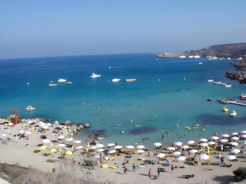 a beach with umbrellas and people in the water at Casa de Nicole in Protaras