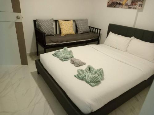 een slaapkamer met een bed met handdoeken erop bij 2 beds front beach in Jomtien Beach