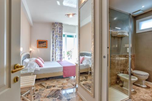 um pequeno quarto com uma cama e um chuveiro em Hotel Villa Europa em Gargnano