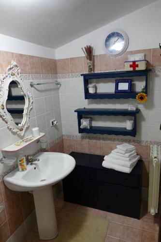 a bathroom with a sink and a mirror and towels at Villa Emily in Licata