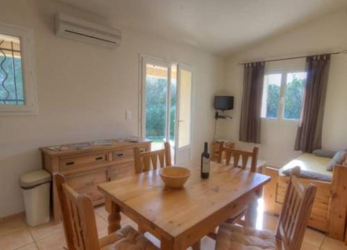 ein Wohnzimmer mit einem Holztisch und Stühlen in der Unterkunft Les bergeries d'Ogliastrello in Figari