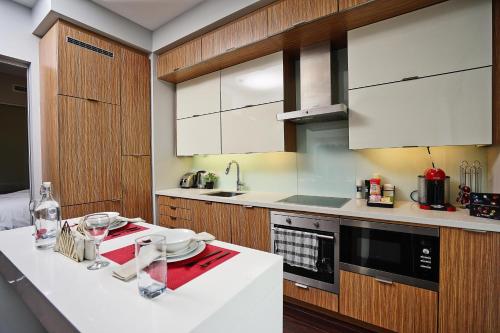 eine Küche mit Holzschränken und einer weißen Arbeitsplatte in der Unterkunft RivetStays - Quaint 1-Bedroom Steps from CN Tower, MTCC, Union Station in Toronto
