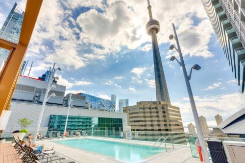 a cruise ship pool with the cn tower in the background at RivetStays - Quaint 1-Bedroom Steps from CN Tower, MTCC, Union Station in Toronto