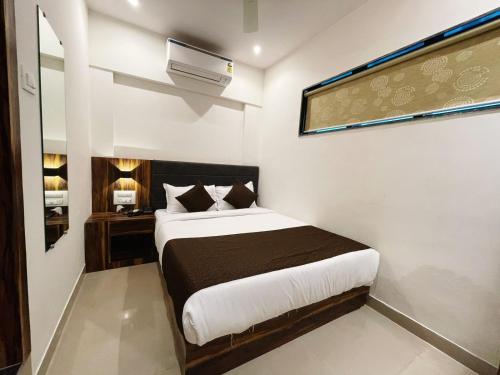 a bedroom with a bed with a black and white sheets at Hotel Hilton Suites in Mumbai