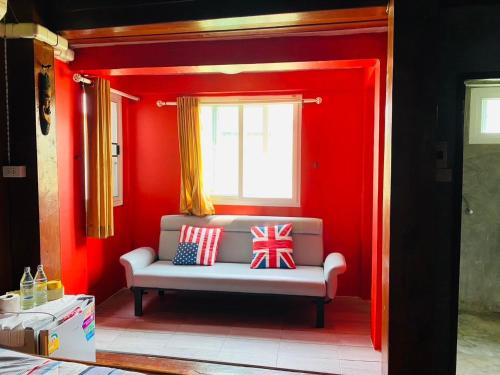 a red room with a bench with patriotic pillows on it at SolarCell walking street Homestay - โซล่าเซลล์ถนนคนเดินโฮมสเตย์ in Ban Nong Nam Khan