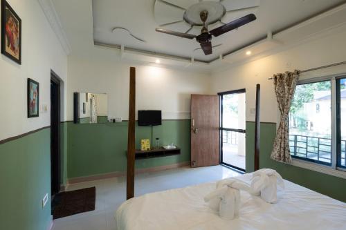 a bedroom with a bed and a ceiling fan at Avadale Tadoba - Stag Groups Not Allowed in Mohurli