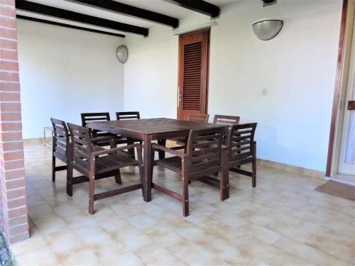 a wooden table and chairs in a room at Holiday home in Bibione 41086 in Bibione
