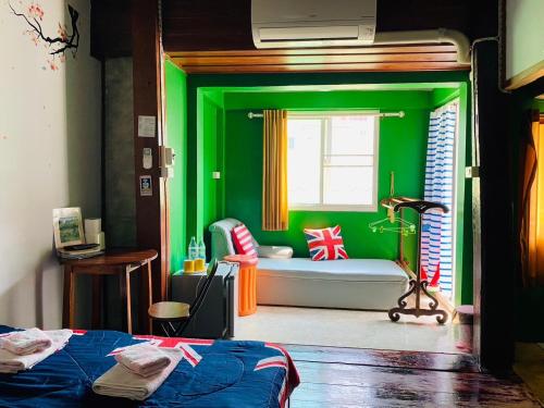 a green room with a bed and a window at SolarCell walking street Homestay - โซล่าเซลล์ถนนคนเดินโฮมสเตย์ in Ban Nong Nam Khan