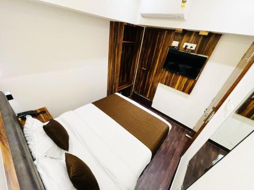 um quarto com uma cama e uma televisão de ecrã plano em Hotel Hilton Suites em Mumbai
