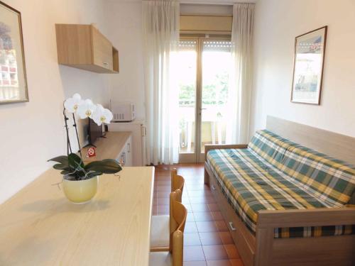 Cette chambre comprend une table, un lit et une cuisine. dans l'établissement Apartments in Bibione 24607, à Bibione