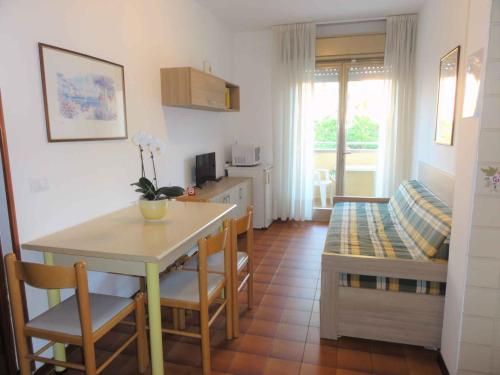 - une cuisine et une salle à manger avec une table et un lit dans l'établissement Apartments in Bibione 24607, à Bibione