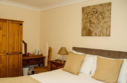 a bedroom with a bed and a table with a lamp at The Ham and Cheese in Scagglethorpe