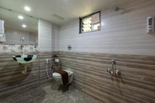 a bathroom with a sink and a toilet at Avadale Tadoba - Stag Groups Not Allowed in Mohurli
