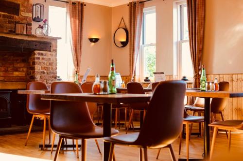 a restaurant with tables and chairs and a fireplace at The Ham and Cheese in Scagglethorpe