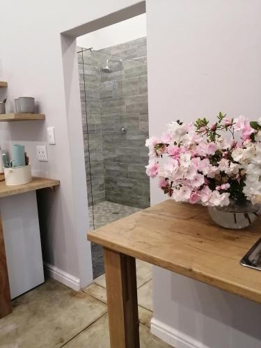 a vase of pink flowers sitting on a table at Cooper Cottage in Howick