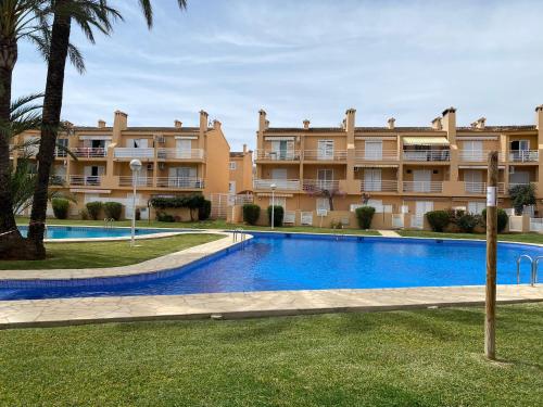 une piscine en face d'un grand bâtiment dans l'établissement ALOJAMIENTO ARENAL PARK, à Jávea