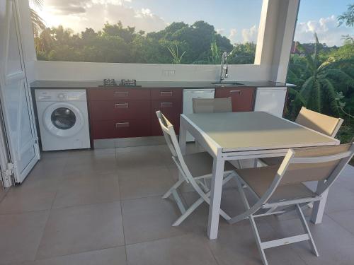 uma cozinha com uma mesa e uma máquina de lavar roupa em TI KAJOU em Saint-François