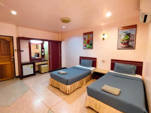 a hotel room with two beds and a bathroom at Srisomthai Hotel in Ubon Ratchathani