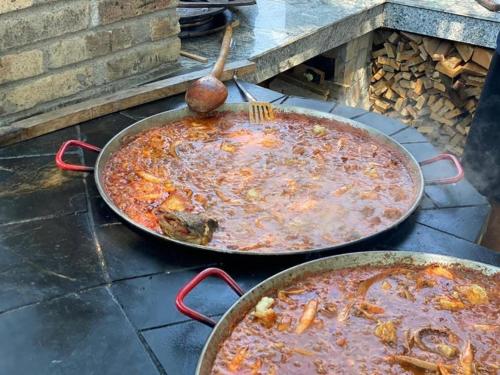 two large pans of food on top of a grill at Pensiunea BELVEDERE YACHTCLUB Berzasca in Berzasca