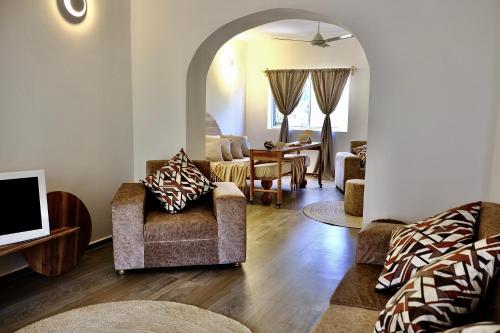 a living room with two chairs and a tv at Antares Villa in Kiwengwa