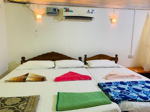 a bedroom with two beds with towels on them at Lacto Cressida in Palolem