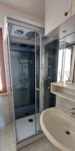 a bathroom with a glass shower and a sink at Casa Adige in Verona
